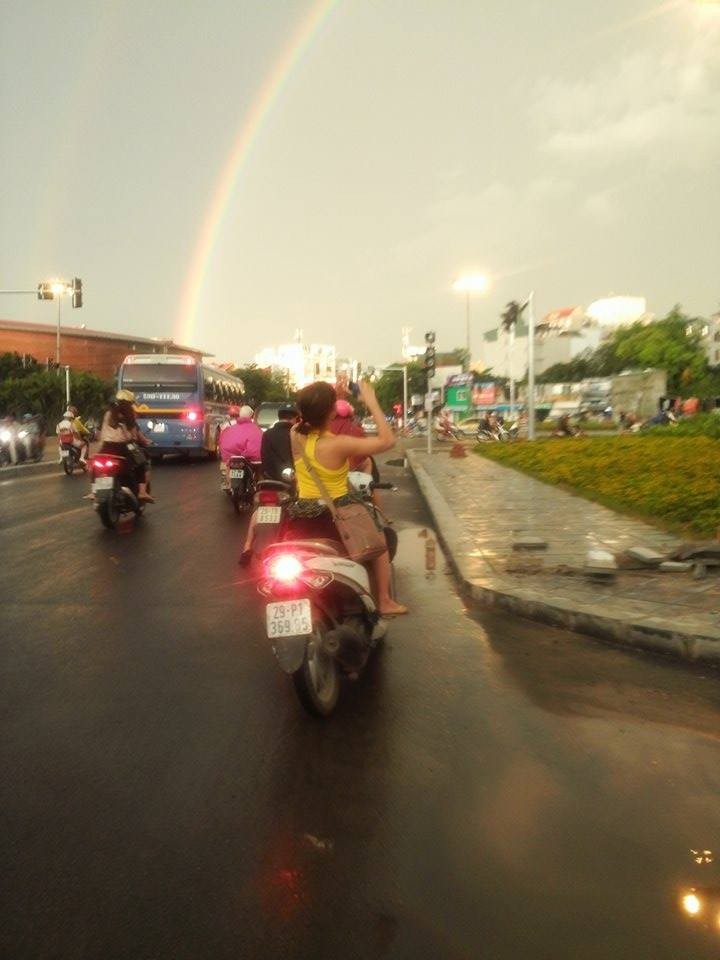 Sau cơn mưa lớn chiều qua (13/6), cầu vồng 7 sắc xuất hiện và trở thành tâm điểm chú ý của nhiều người. Một số người đi đường đã dừng lại chụp ảnh hiện tượng thiên nhiên tuyệt vời  cầu vồng sau mưa giông trên bất chấp những mối nguy hiểm rình rập.